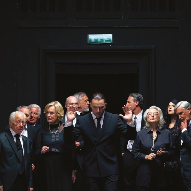 Copertina dell'album per soldi e per amore di Ernia. Ernia al centro vestito d'affari.